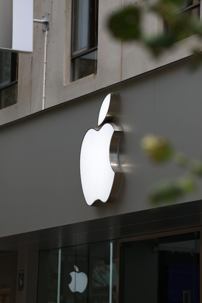 Close-up of Apple Store exterior featuring the illuminated logo prominently displayed.